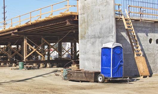 a row of sturdy portable toilets at a work site